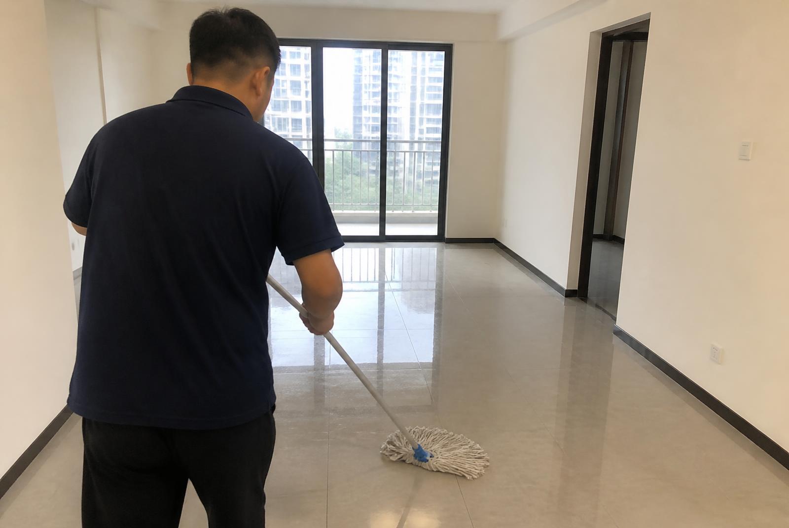 GÖKEVİM Temizlik personeli, geniş ve aydınlık bir salonun parlak zeminini profesyonel ekipmanla paspaslıyor
